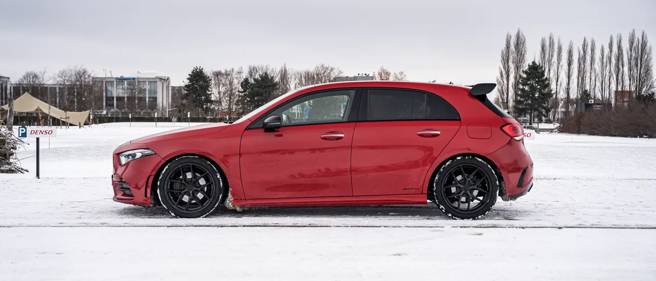 Mercedes-AMG A 45 S de profil sur un terrain enneigé, reprise FASTAUTO.BE.